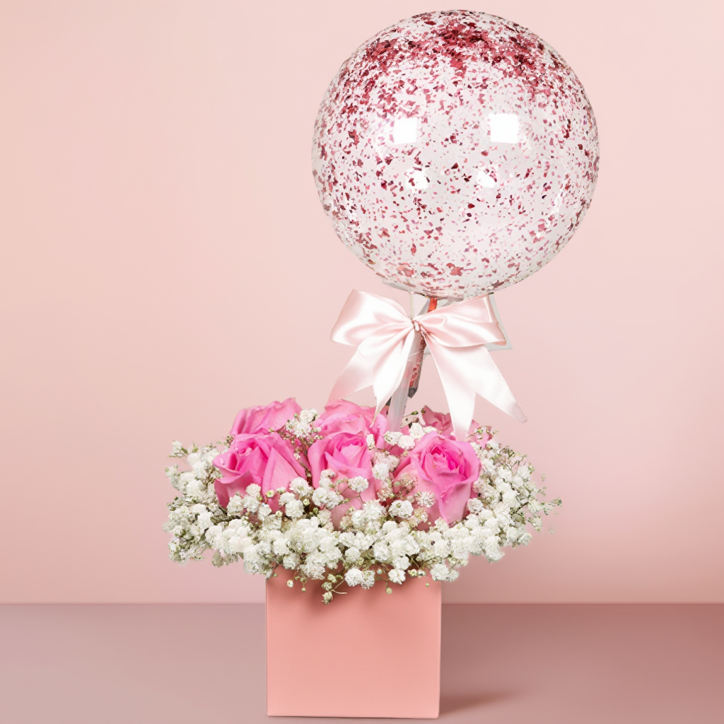 Luxury black flower box with pink roses, gypsophila flowers, eucalyptus, and a decorative hot air balloon beautifully arranged in an elegant floral design.