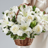 Bouquet of white flowers in a wicker basket held by a person against a neutral background