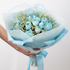Bouquet of blue flowers wrapped in light blue paper with a ribbon, held by a person against a white background.