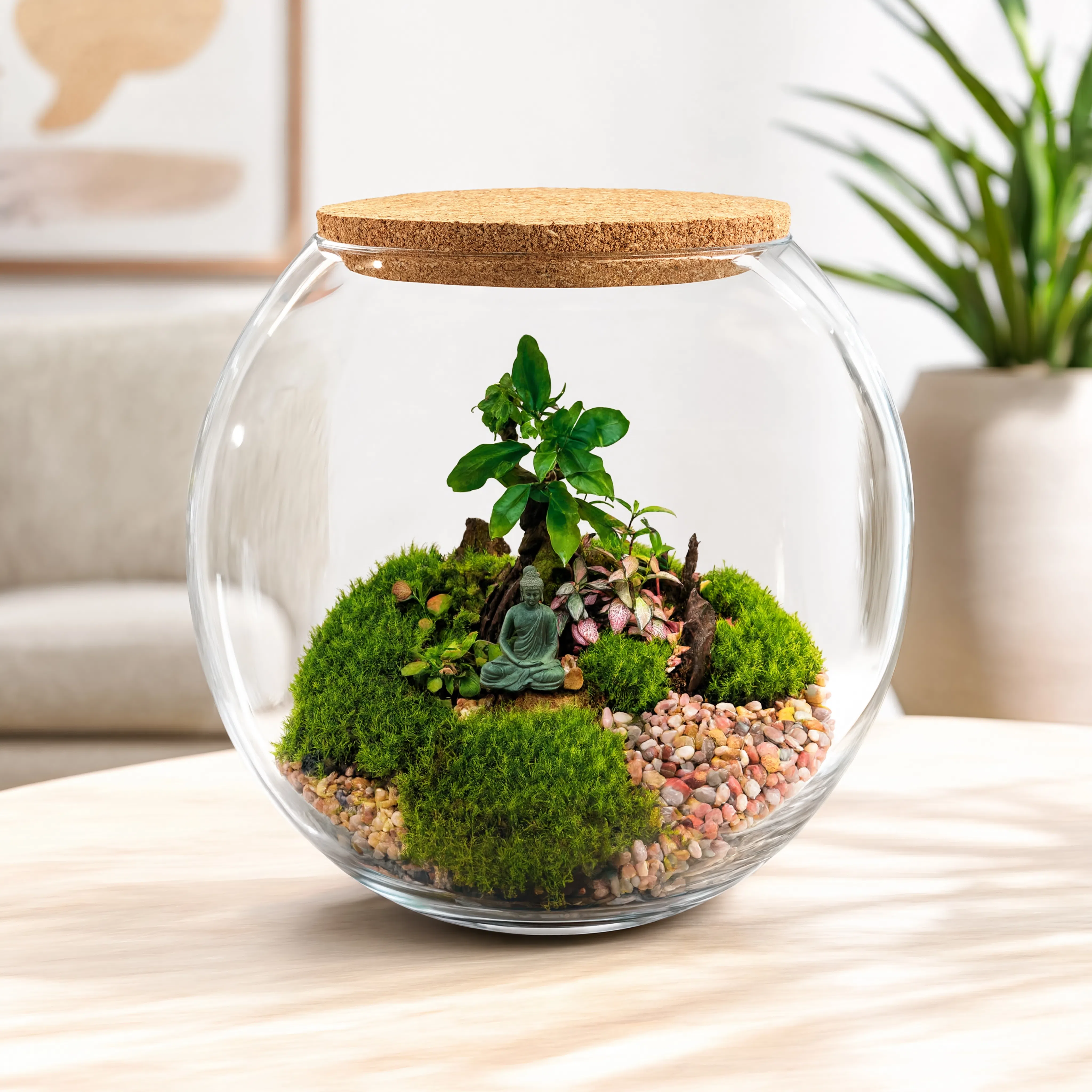 Handmade Zen Buddha bonsai terrarium in a round glass bowl with preserved moss, miniature plants, decorative pebbles, and a cork lid.