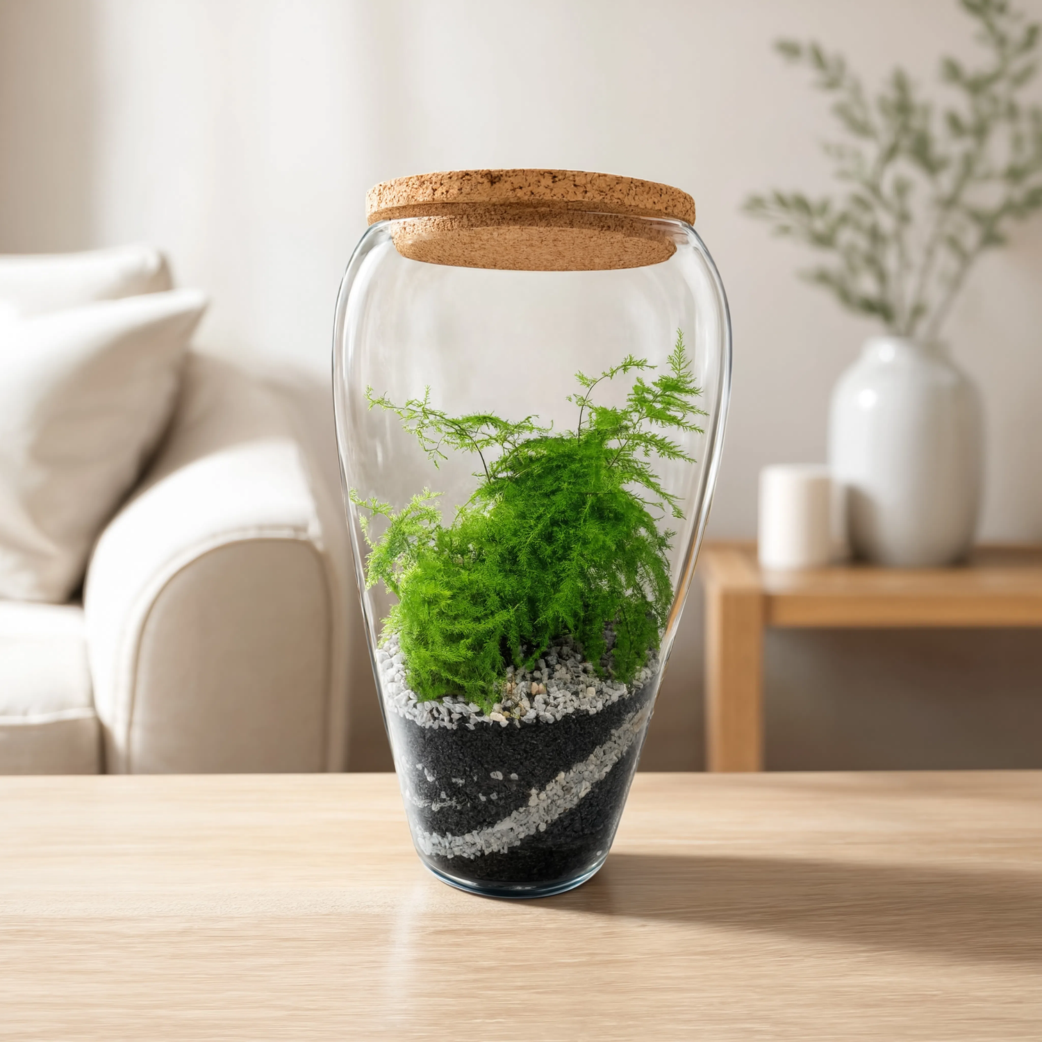 Handmade fern glass jar terrarium with lush green fern, decorative layered black and white substrate, and natural cork lid for indoor home décor.