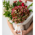 Bouquet of flowers held by a person on a plain background