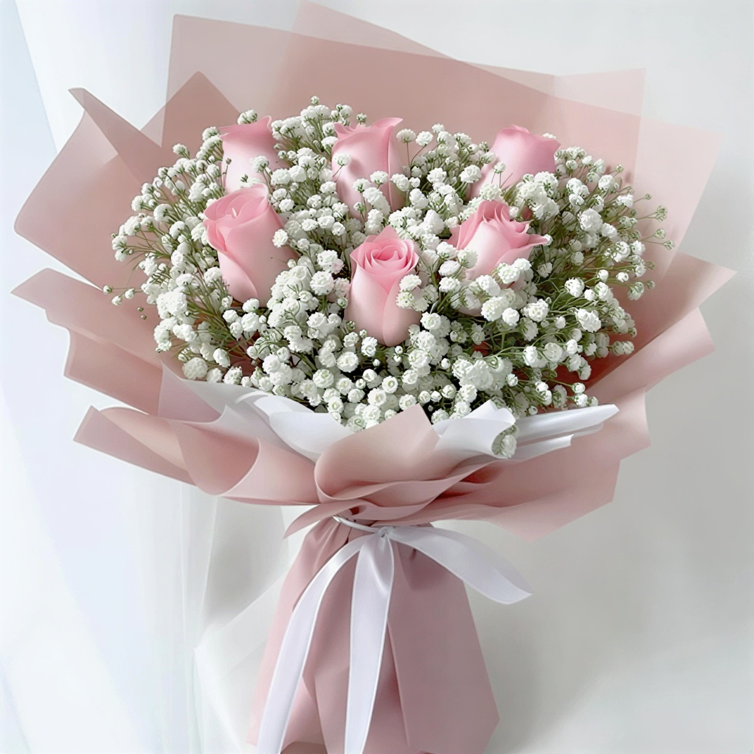 Bouquet of pink roses and baby's breath wrapped in pink paper with a white ribbon on a light background