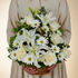 Elegant pyramid-style basket arrangement with white roses, assorted white flowers, and seasonal foliage beautifully crafted in a luxury floral design.